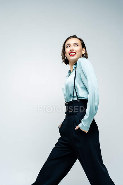 Portrait of a beautiful woman walking with her hands in her pockets — Stock Photo