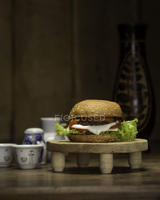 Close-up of a hamburger on a wooden pedestal — Stock Photo