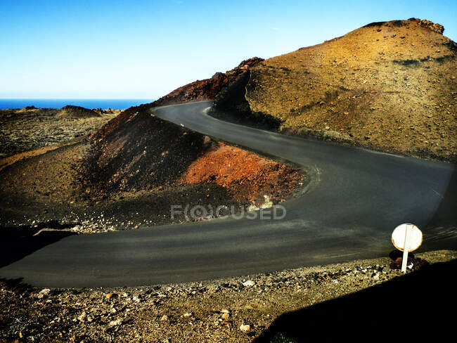 Estrada sinuosa através de campos de lava, Lanzarote, Ilhas Canárias, Espanha — Fotografia de Stock