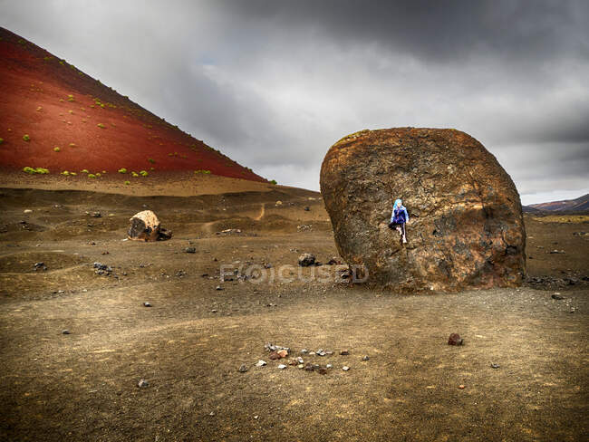 Menina escalando uma rocha gigante, Lanzarote, Ilhas Canárias, Espanha — Fotografia de Stock