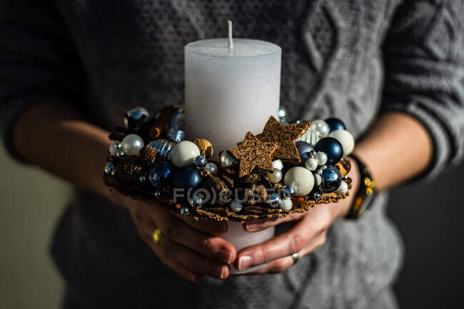 Primo piano di una donna che tiene una decorazione di candela di Natale — Foto stock