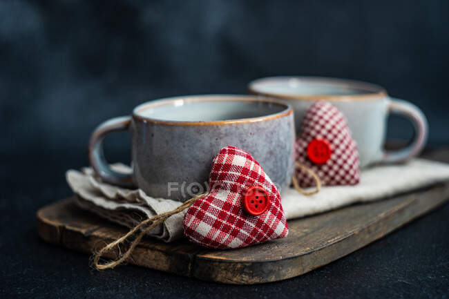 Tasses en céramique et décoration en forme de coeur textile pour le dîner de Saint-Valentin — Photo de stock