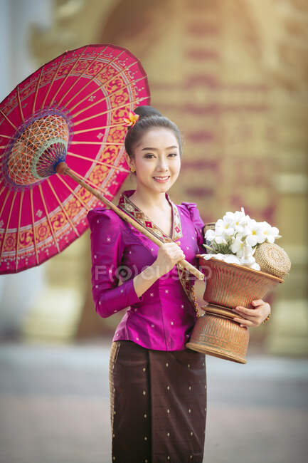 Retrato de uma bela mulher segurando uma cesta com flores frescas, Tailândia — Fotografia de Stock