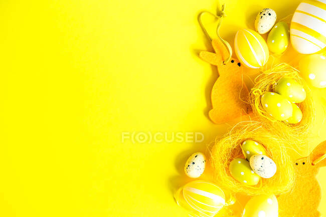 Easter egg and Easter bunny arrangement on a yellow background — Stock Photo
