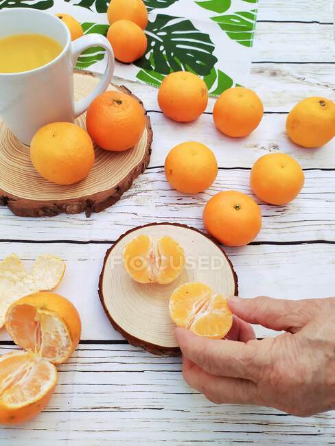 Woman's hand reaching for a satsuma — Stock Photo
