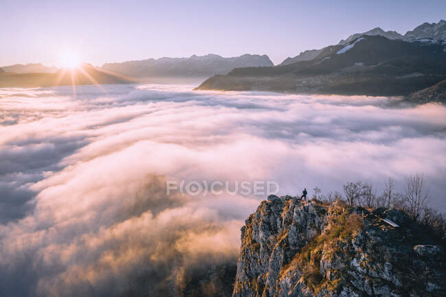 Uomo in piedi sulla cresta della montagna che si erge sopra il tappeto nuvoloso, Hallein, Salisburgo, Austria — Foto stock