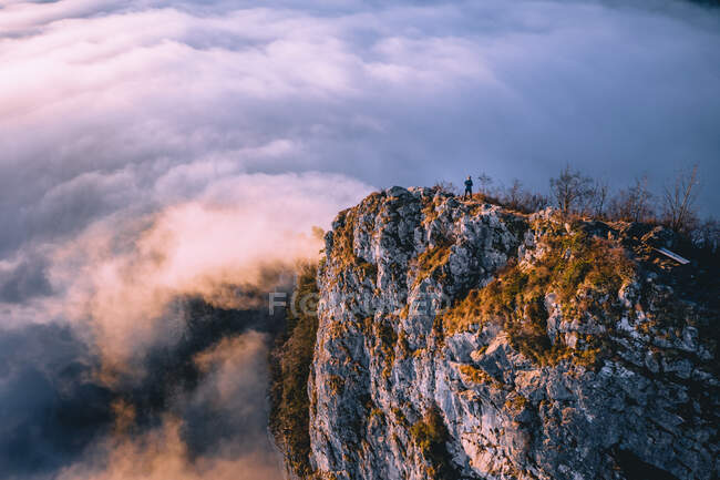 Mann steht auf Bergrücken über dem Wolkenteppich, Hallein, Salzburg, Österreich — Stockfoto