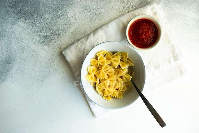 Pasta with tomato sauce and basil on a white plate — Stock Photo