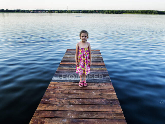 Mädchen steht auf einem Holzsteg an einem See, Polen — Stockfoto