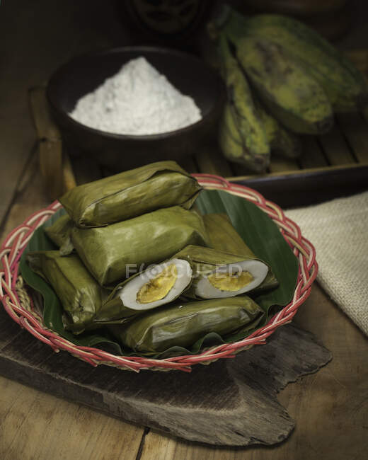 Bowl of Indonesian rice cakes in banana leaves — Stock Photo