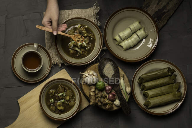 Вид сверху на человека, наслаждающегося традиционной индонезийской едой Лонтонг Кикиль — стоковое фото