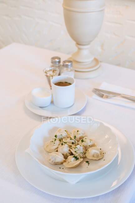 Bowl of Russian pelmeni dumplings on a table in a restaurant — Stock Photo