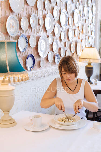 Frau sitzt in Restaurant und isst Knödel — Stockfoto