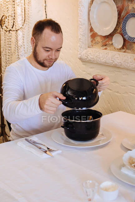 Man eating steamed mussels in a restaurant — Stock Photo