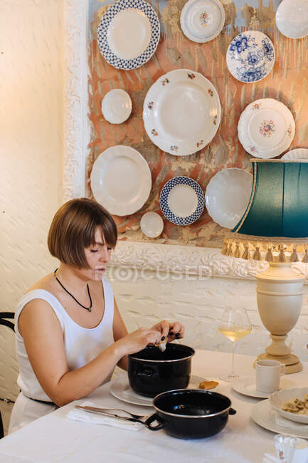 Woman sitting in a restaurant eating mussels — Stock Photo