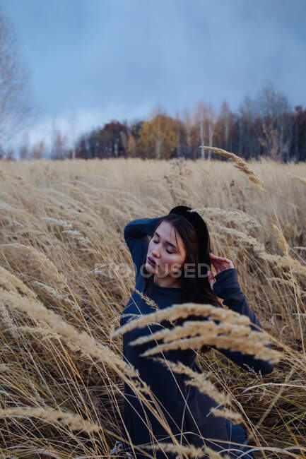 Портрет красивой женщины, сидящей в поле осенью, Россия — стоковое фото