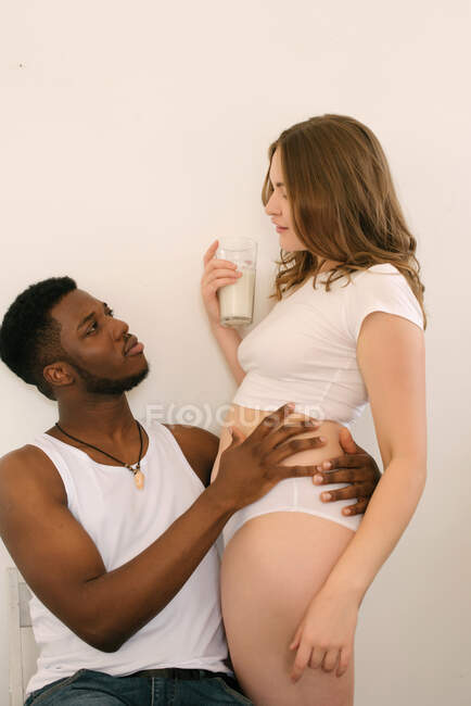 Close-up of a man embracing a woman holding a glass of milk — Stock Photo