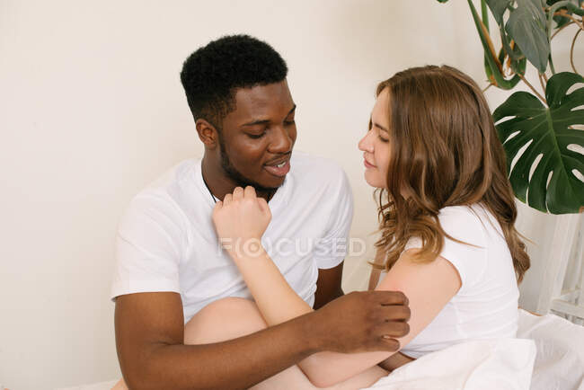 Portrait of a Mixed race couple sitting on a sofa looking at each other — Stock Photo
