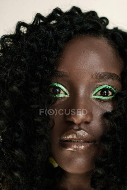 Retrato de una hermosa mujer africana con maquillaje verde - foto de stock