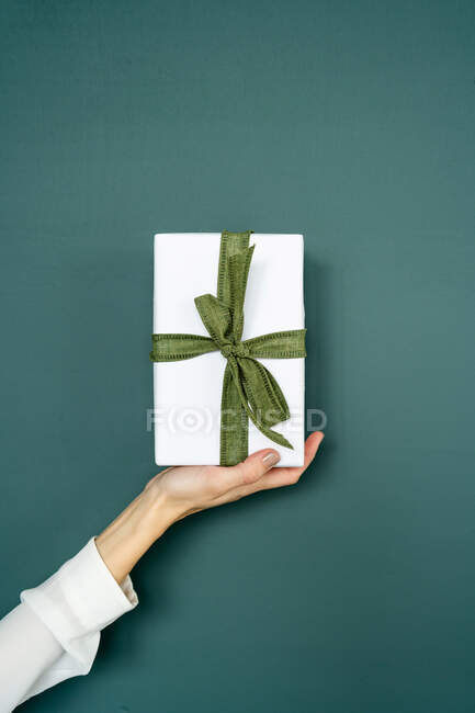 Woman's hand holding a wrapped gift — Stock Photo