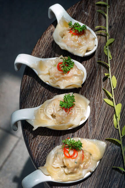 Four chicken dumpling appetizers on spoons — Stock Photo