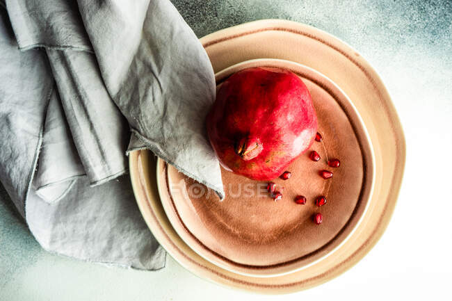 Pomegranates and pomegranate seeds in a bowl — Stock Photo