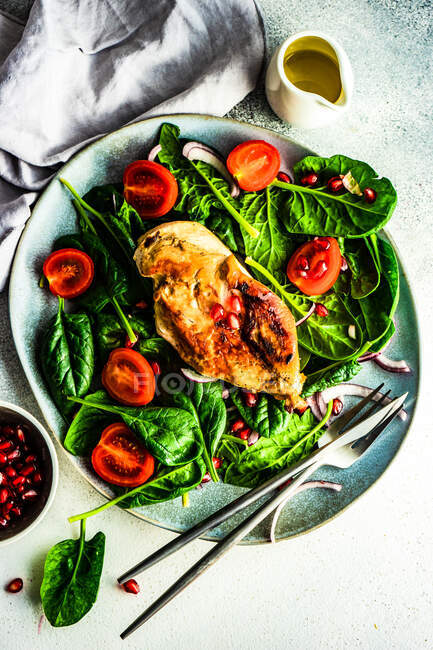 Gesundes Ernährungskonzept mit frischem Bio-Spinatblättersalat und gegrilltem Hähnchen auf rustikalem Hintergrund mit Kopierraum — Stockfoto