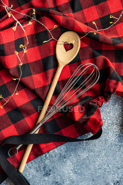 Bate y cuchara de madera en un delantal - foto de stock