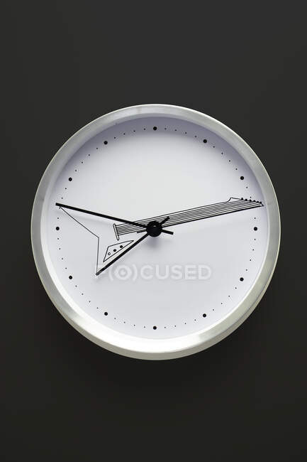 White clock hanging on black wall — Stock Photo