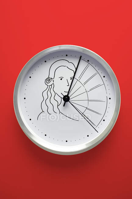Reloj de pared conceptual con mujer sosteniendo un ventilador - foto de stock