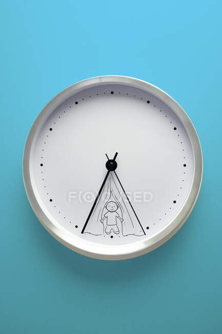 Conceptual wall clock with person kneeling at the entrance of a tent — Stock Photo