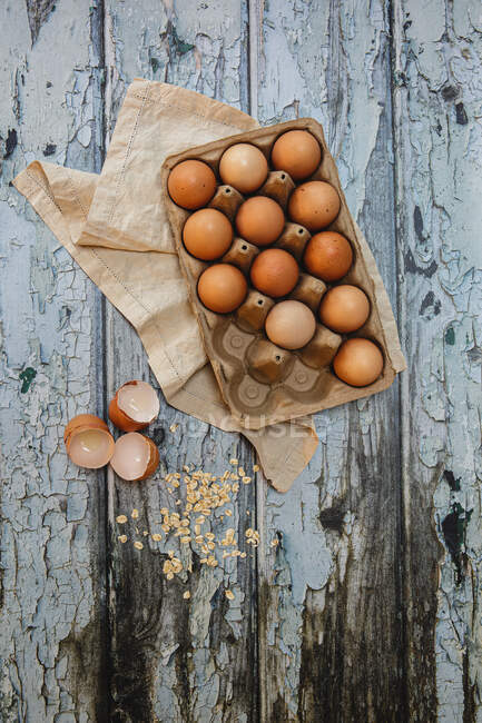 Cardboard carton with free range eggs on a rustic table — Stock Photo