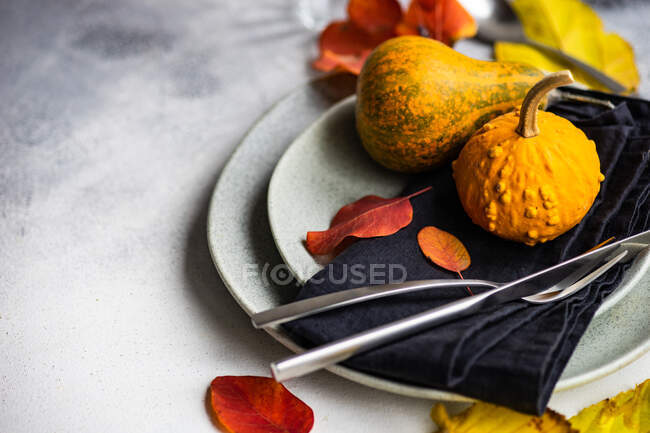 Entorno de lugar otoñal con hojas de otoño y decoraciones de calabaza - foto de stock