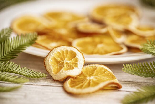 Assiette d'oranges séchées sur une table avec branches de sapin pour Noël — Photo de stock