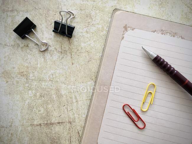 Vista aérea de un cuaderno abierto, lápiz y clips de papel - foto de stock