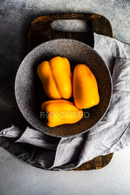 Fresh vegetables, yellow bell pepper in stone bowl — Stock Photo