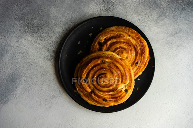 Только что испеченные булочки с изюмом на деревянной тарелке в качестве концепции десертной еды — стоковое фото