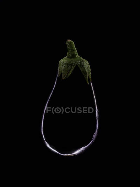 Silhouette of an aubergine against a black background — Stock Photo