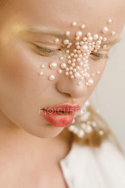 Retrato de uma menina bonita com pérolas no rosto — Fotografia de Stock