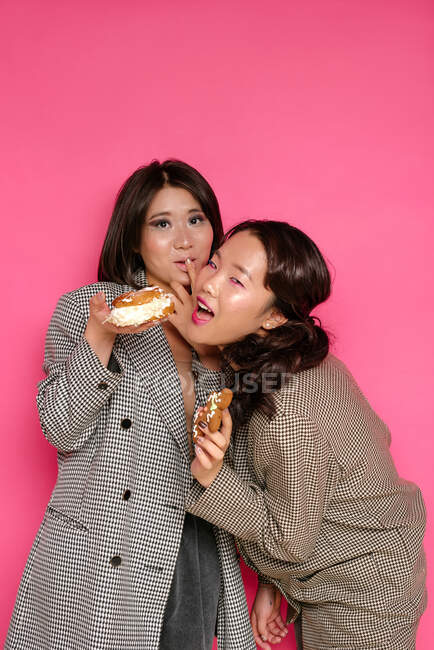 Retrato de dos mujeres comiendo pasteles - foto de stock