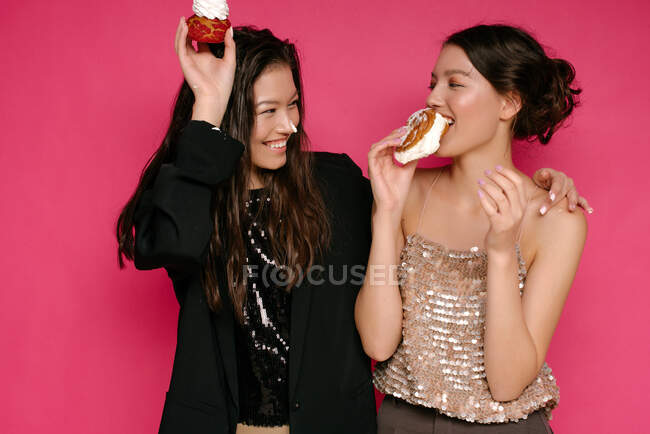 Retrato de dos mujeres comiendo pasteles - foto de stock