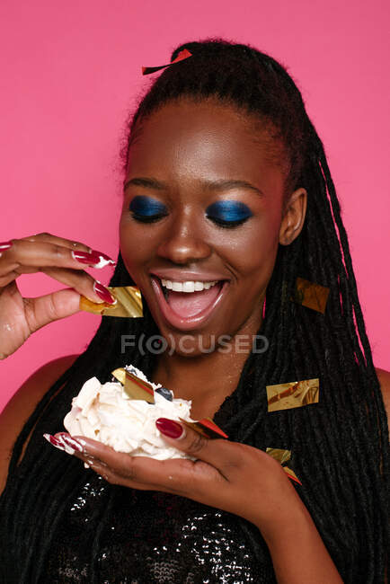 Porträt einer schönen Frau, die einen Kuchen isst — Stockfoto