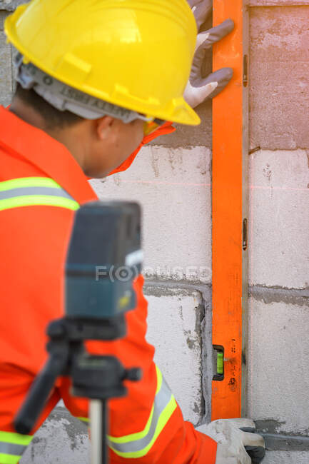 Trabajador de la construcción utilizando un nivel de espíritu en un sitio de construcción, Tailandia - foto de stock
