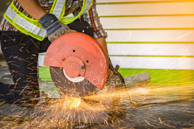 Construction worker using an electric saw on a building site, Thailand — Stock Photo