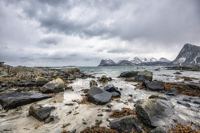 Playa rocosa y paisaje de montaña, Lofoten, Nordland, Noruega - foto de stock