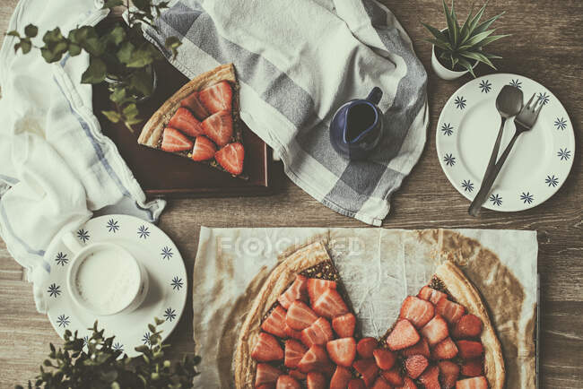 Overhead view of strawberry tart with a cup of milk — Stock Photo