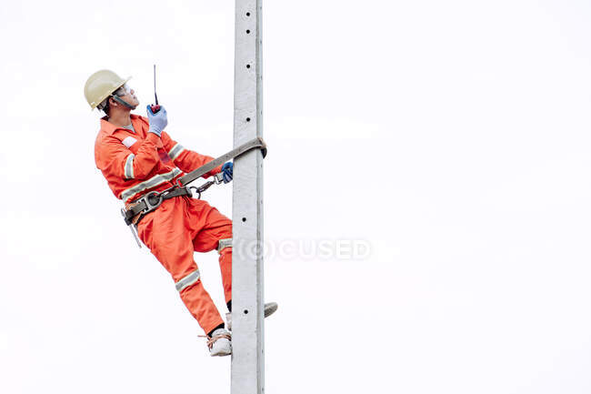 Ouvrier de la construction grimpant un poteau métallique, Thaïlande — Photo de stock