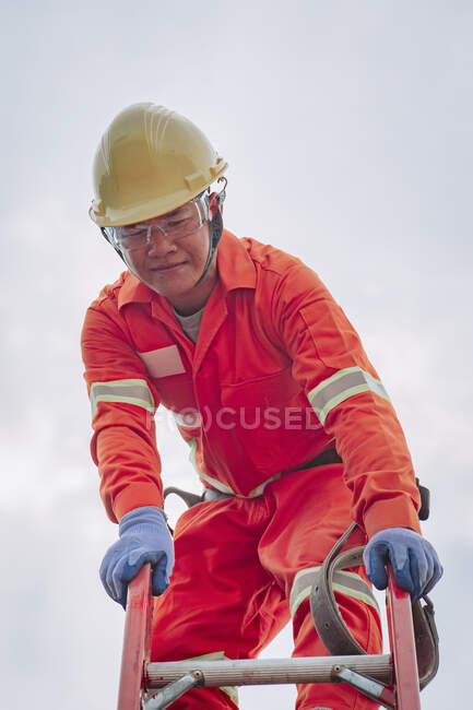 Ouvrier de la construction debout au sommet d'une échelle, Thaïlande — Photo de stock