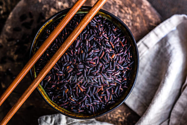 Arroz negro orgánico crudo en un tazón como concepto de cocina asiática - foto de stock