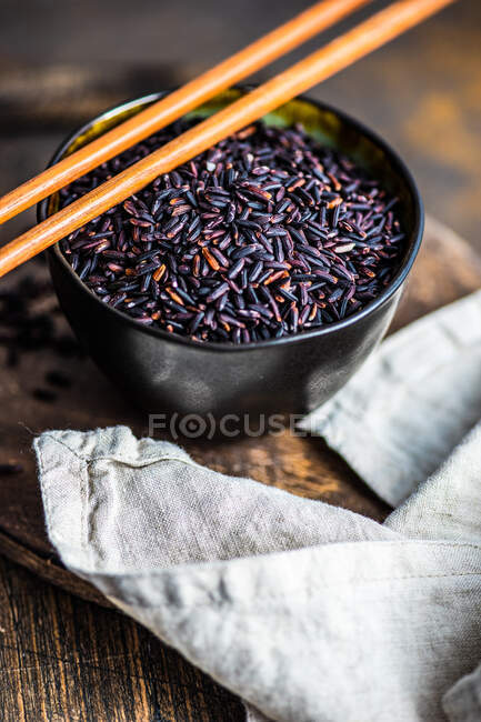 Arroz preto orgânico cru em uma tigela como um conceito de cozinha asiática — Fotografia de Stock